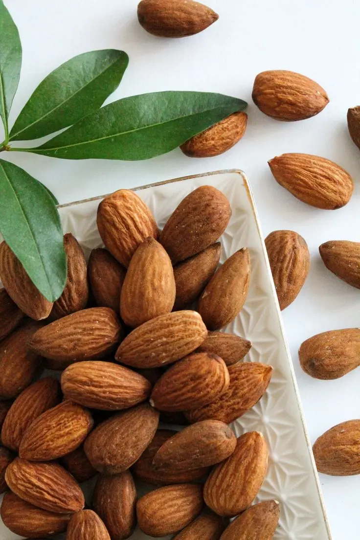 مغز بادام در یک ظرف چوبی با بافت خشک و رنگ یکدست