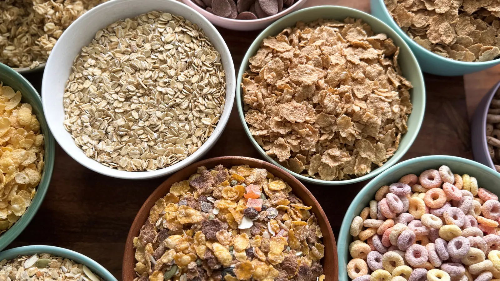 چندین نوع غلات صبحانه در ظرف شیشه‌ای با لöffel