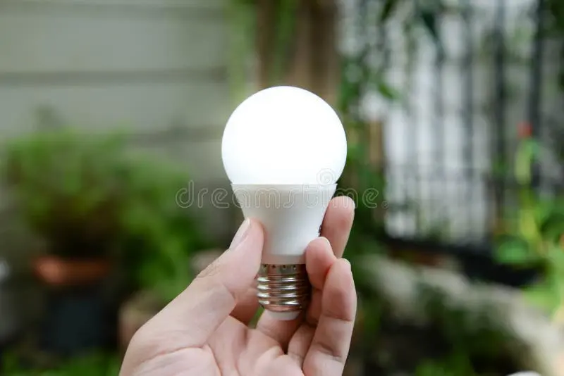 لامپ LED جدید با فناوری انرژی سبز و دست انسان در حال نگهداری آن