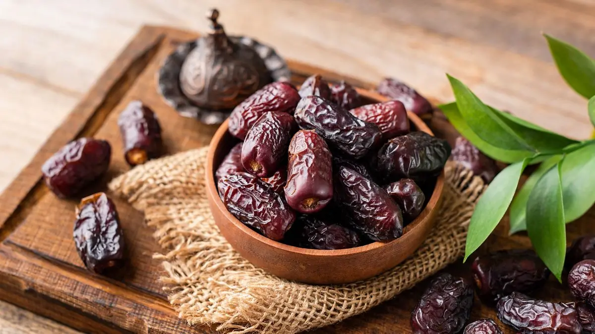 یک سبد پر از خرماهای مختلف در یک بازار سنتی