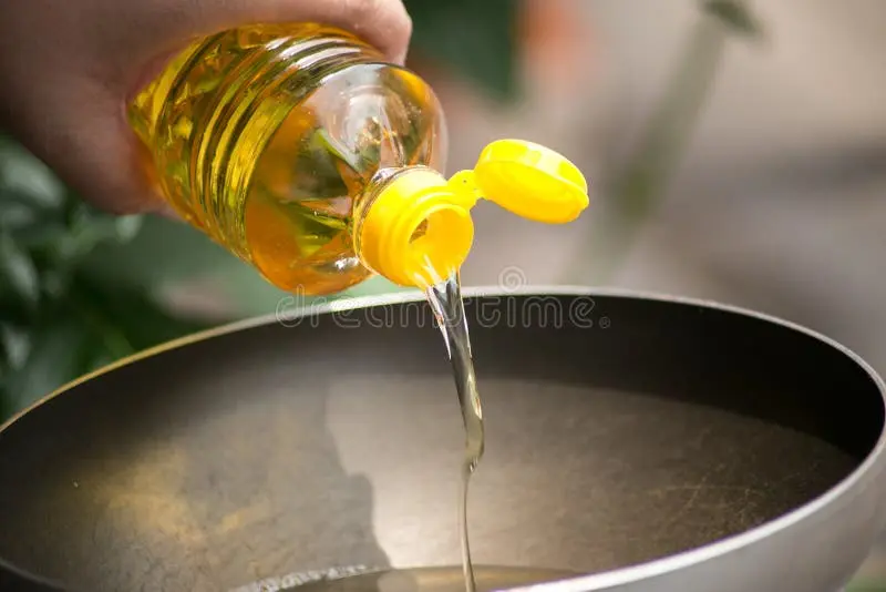 روغن گیاهی در بطری پلاستیکی و در حال ریختن به کاسه سرخ کردن