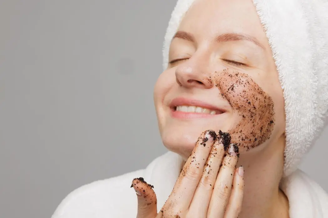 زنی در حال استفاده از اسکراب کافئین برای پوست صورت