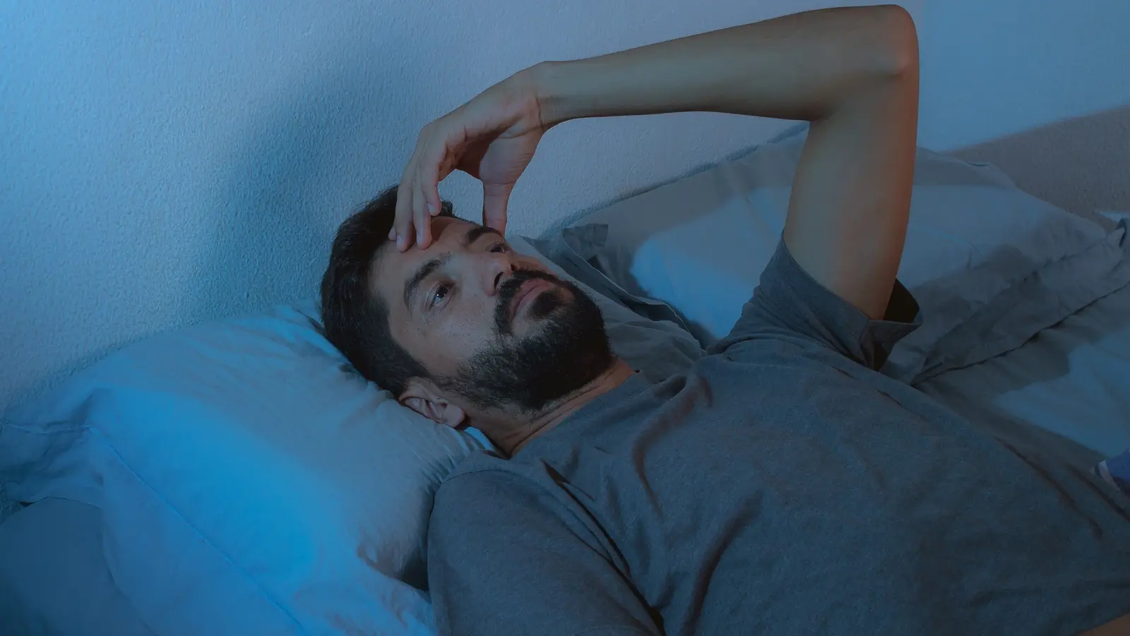 کودکی در حال خوابیدن در بستر نرم با پتو رنگی