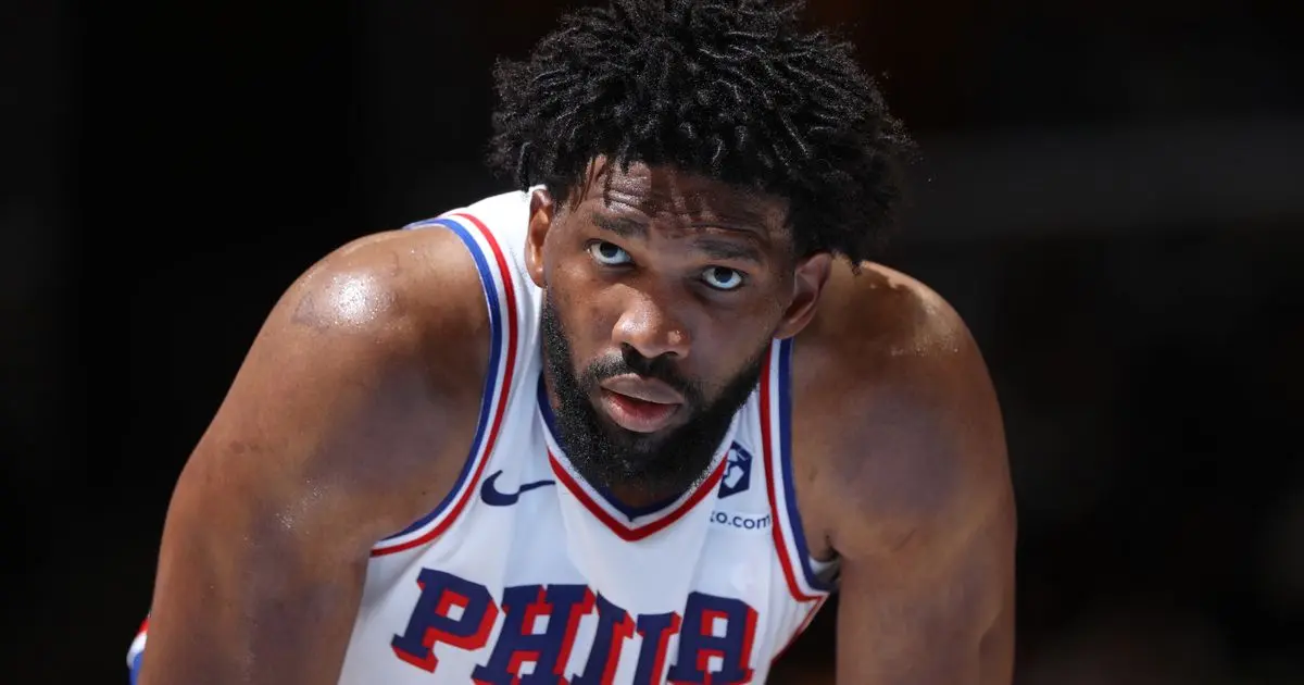 جوئل امبید در حال دریافت جایزه MVP فینال NBA از دست یک مربی
