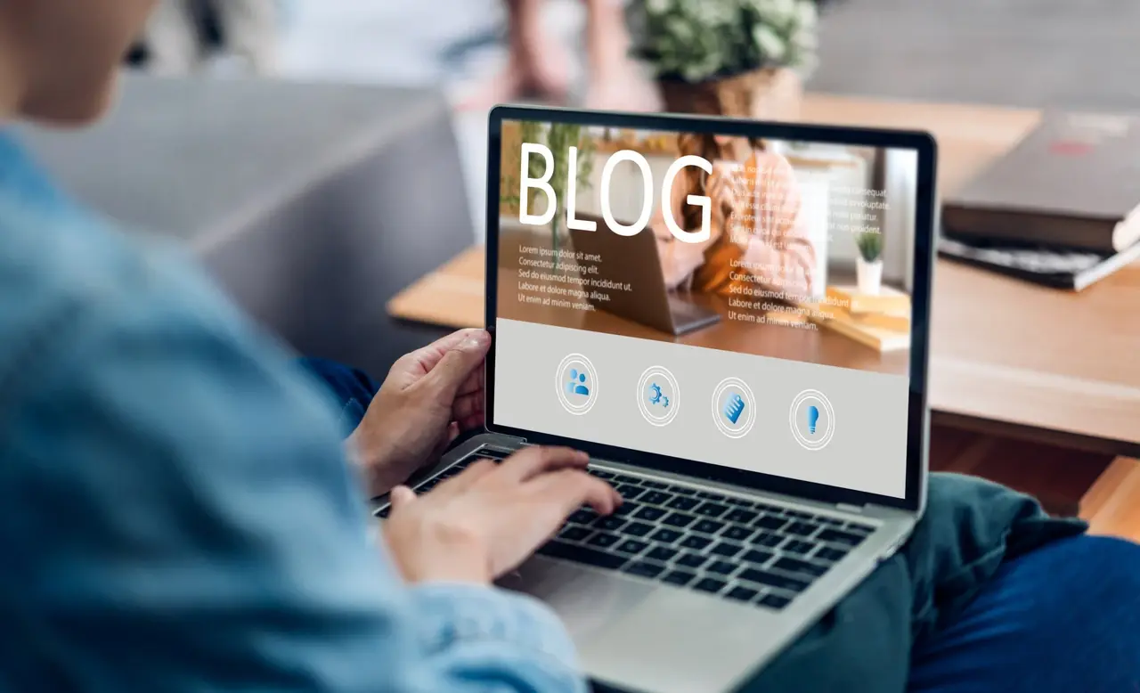 یک فرد در حال کار روی لپتاپ با صفحه وبلاگ باز