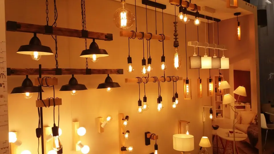 یک اتاق مدرن با نورپردازی بدون لوستر و استفاده از چراغ‌های دیواری و LEDهای داخل کابینت