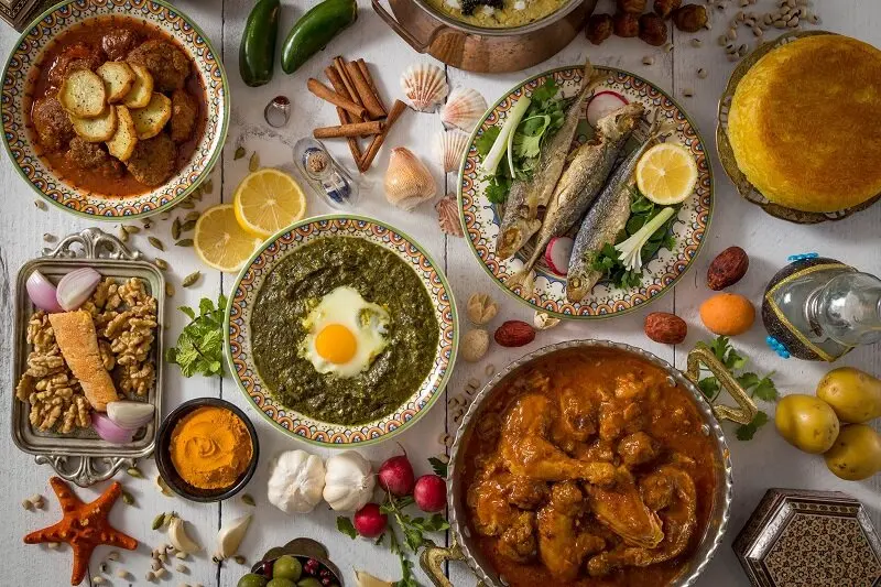 یک ظرف بزرگ دلمه گیلانی با سبزیجات تازه و مواد اولیه سنتی