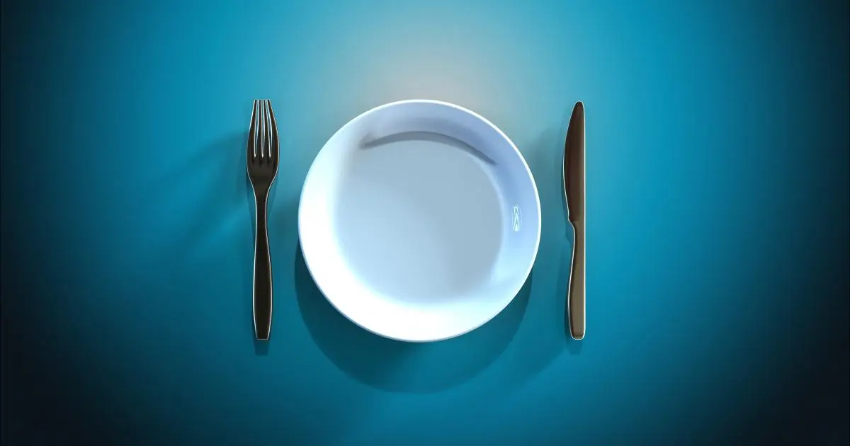 یک صحن خالی با یک چنگال و قاشق برای نشان دادن مفهوم روزه‌داری و خودداری از خوردن