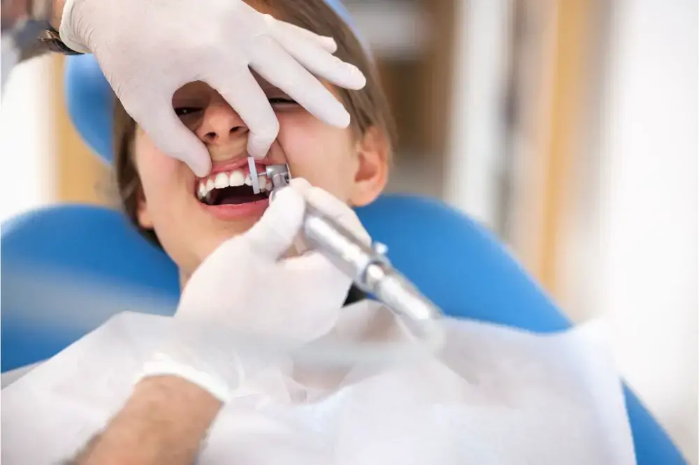 دندانپزشک در حال پاکسازی سطح دندان با ابزار تخصصی