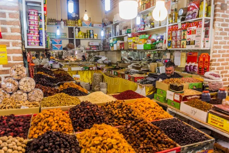 دکانی سنتی در بازار اردبیل با میوههای خشک مختلف و بستهبندیهای چوبی