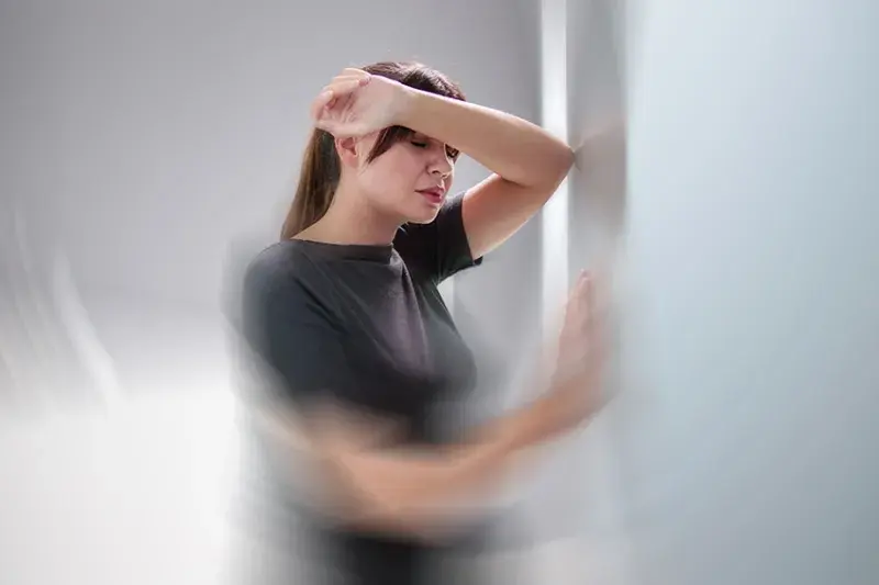 A person experiencing dizziness with a hand on their head, illustrating severe vertigo symptoms