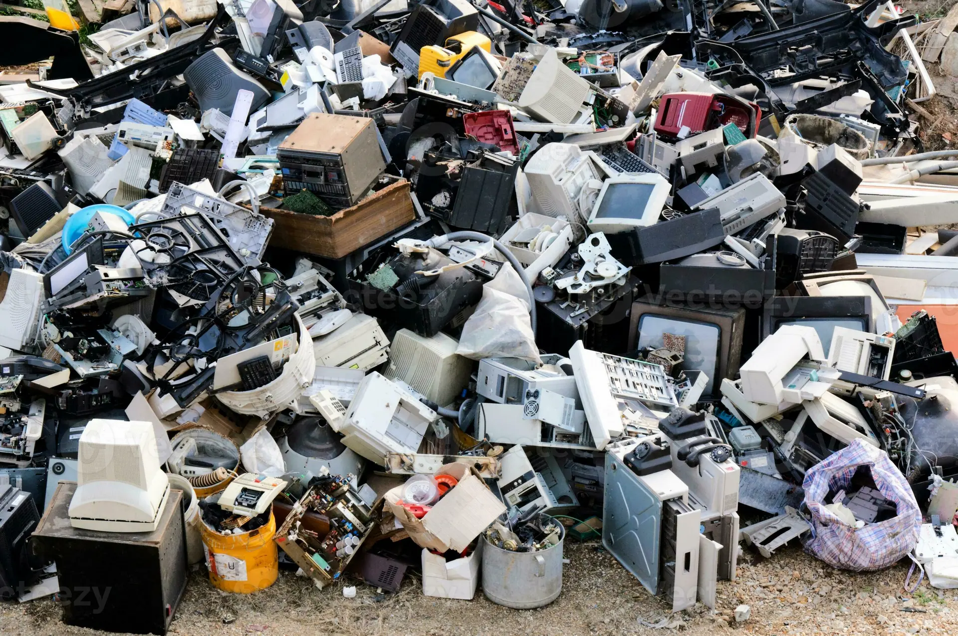 نمای کلی از زبالههای الکترونیکی در یک انبار با دستگاههای قدیمی و قطعات الکترونیکی