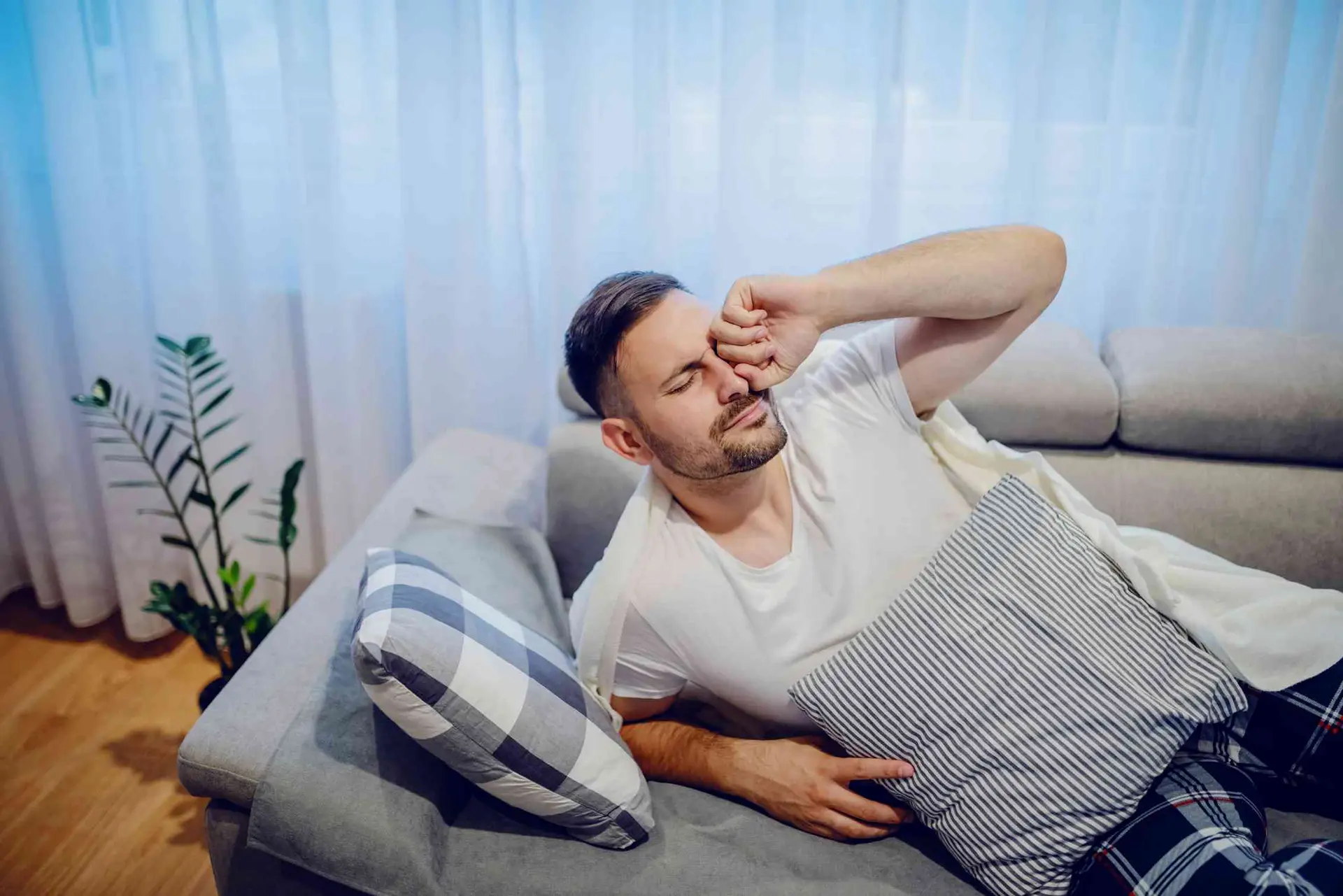 یک فرد در حال استراحت روی یک صندلی با چشمهای بسته و لبخند آرامشبخش