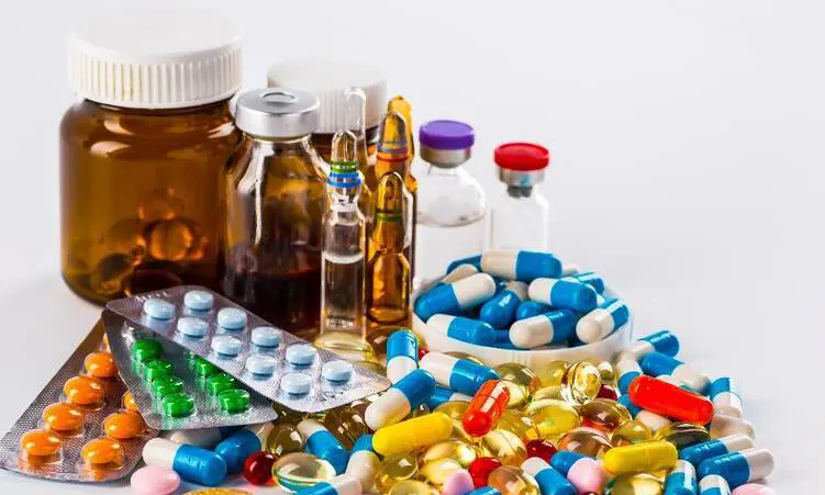 یک دست در حال گرفتن یک بسته دارو از قفسه داروخانه