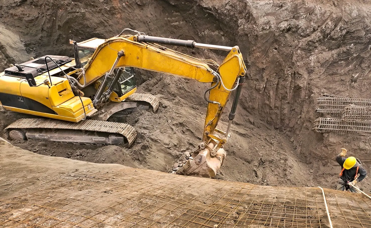 یک حفار در حال استفاده از تجهیزات مدرن برای حفر گودال در یک پروژه عمرانی